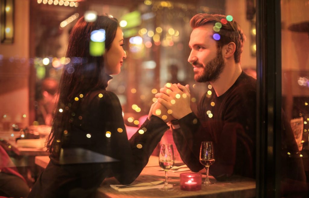 Couple holding hands at a restaurant table