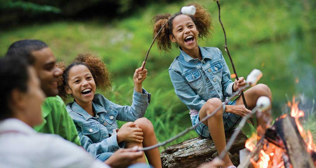 Girls camping maing s'mores