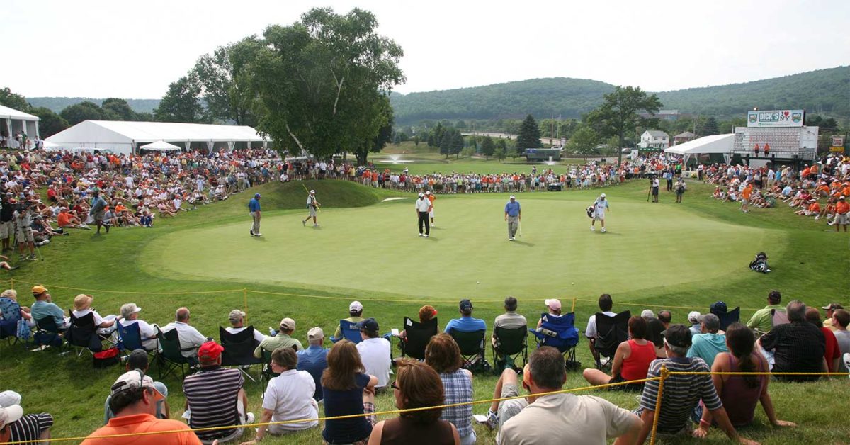 Spectators watching golfers on the green